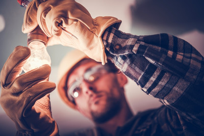 electrician fitting low energy light bulb